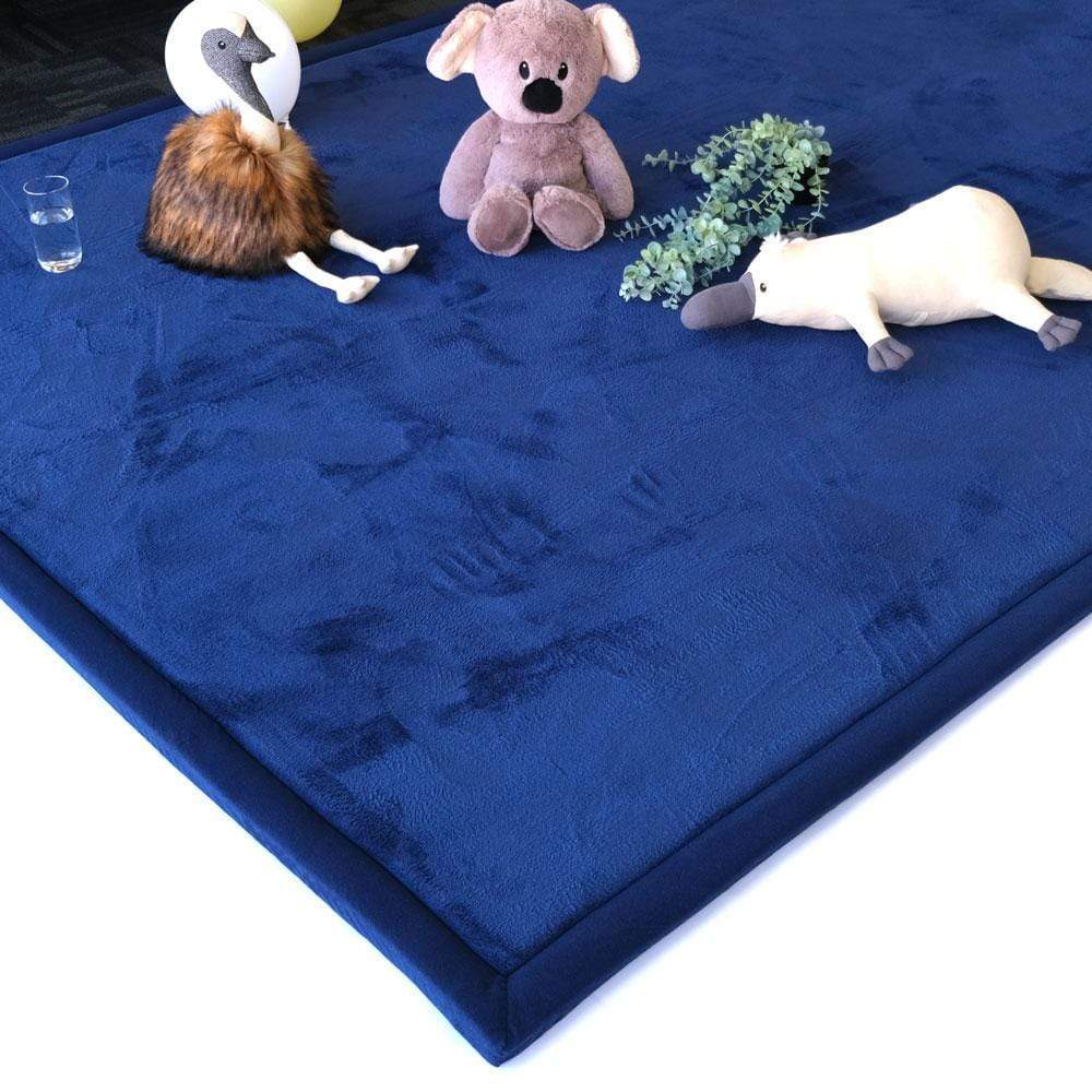 Stuffed plush toys on a blue padded mat.